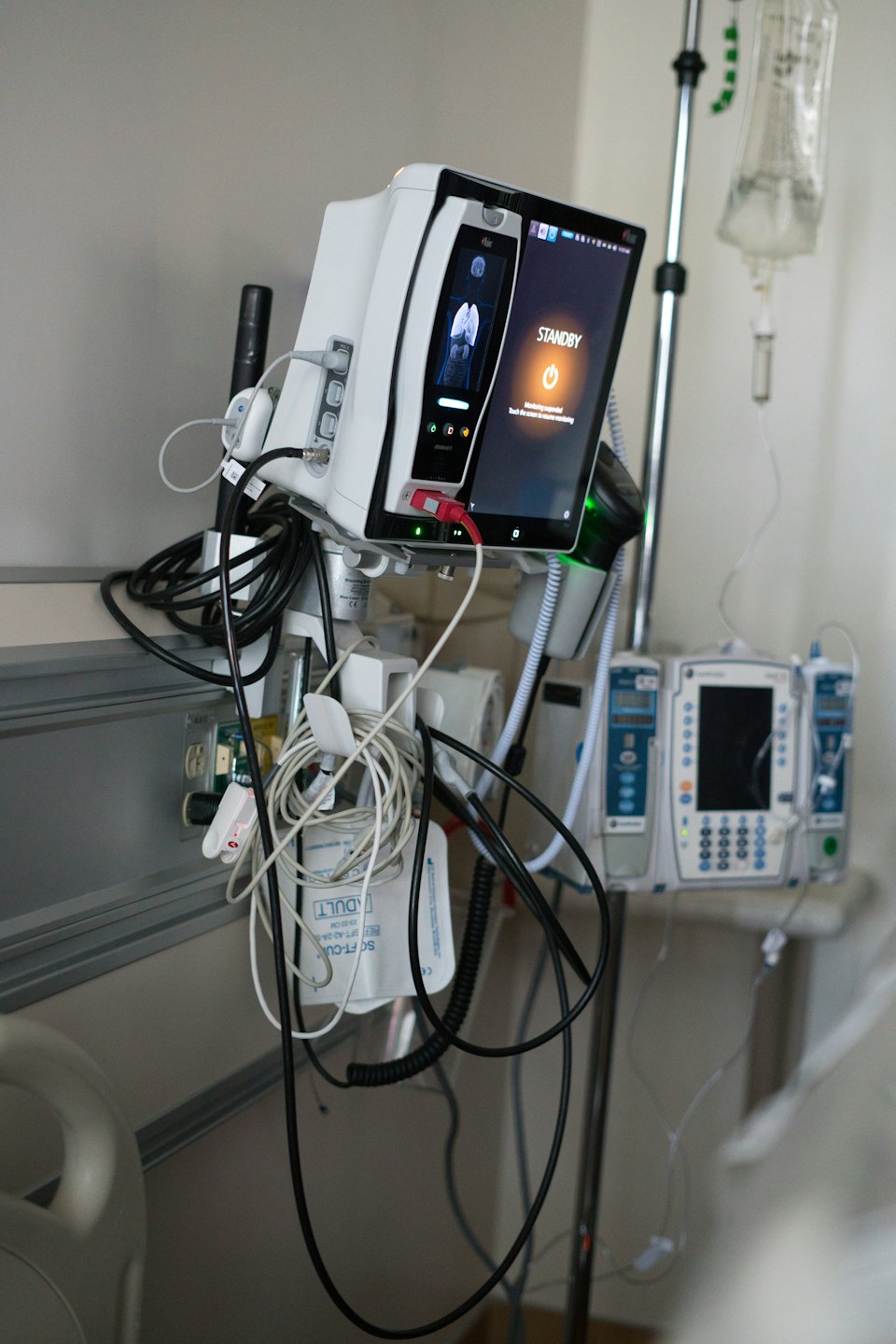 Medical monitors and equipment displaying patient data in a hospital.