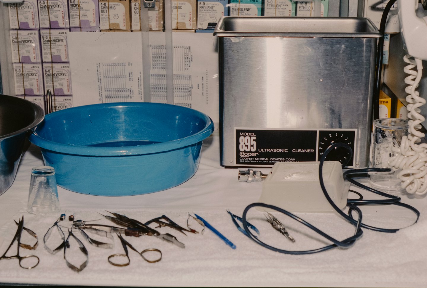 Surgical instruments and ultrasonic cleaner on a table.